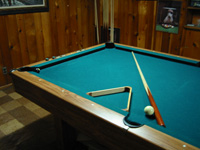 Photo of cue stick, cue ball, rack and pool table