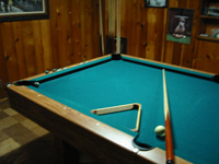 Photo of pool table with rack and cue and cue ball